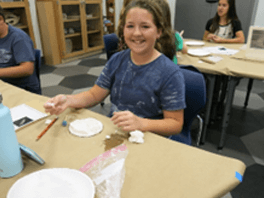 Young girl making crafts during IQuest at The Bishop Museum of Science and Nature