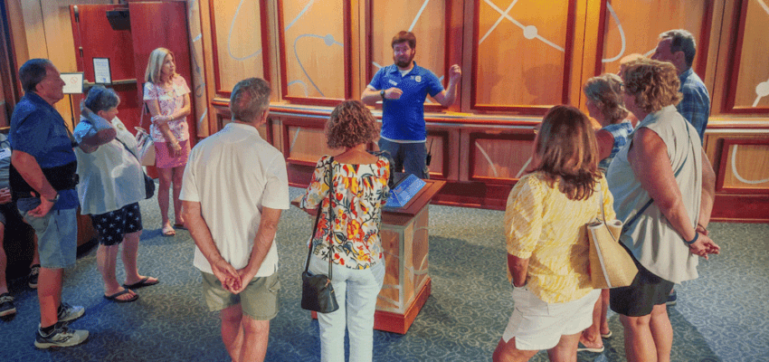 Image of an employee of The Bishop Museum of Science and Nature giving a tour to a group of adults.