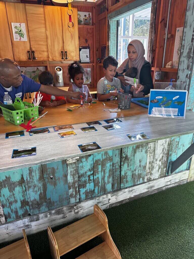 Image of children and adults assembling crafts at the Backyard Science program at the Bishop Museum of Science and Nature.