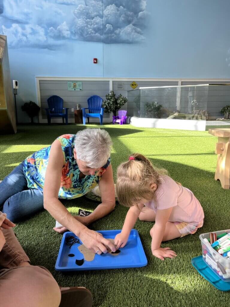 Image of a grandmother and granddaughter doing an activity together at the Backyard Science program at the Bishop Museum of Science and Nature.