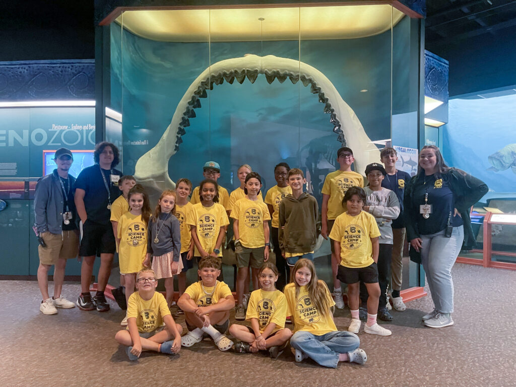 Campers pose for a group picture in front of the Megalodon jaws.